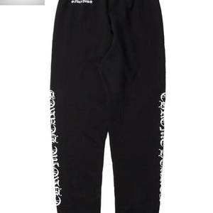 May include: Black sweatpants with white lettering down the sides and on the back. The text includes the words "Chrome Hearts". The sweatpants have an elastic waistband and cuffs.