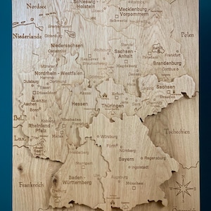 Deutschlandkarte aus massiver Eiche – 3D Relief Holzkarte, schwarz gravierte Städte & Grenzen, Sehenswürdigkeiten mit Rahmen