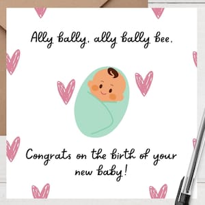 Può includere: Biglietto di auguri per baby shower con un bambino dei cartoni animati avvolto in una coperta verde chiaro, circondato da cuori rosa. Il biglietto dice "Ally bally, ally bally bee" e "Congratulazioni per la nascita del tuo nuovo bambino!" Include una busta marrone e una penna.
