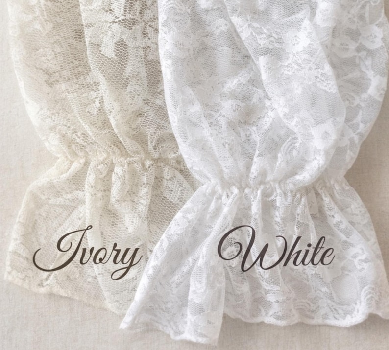 May include: Close-up of two lace fabric samples, one ivory and one white. The delicate lace is gathered at the bottom, creating a ruffled effect. The word "Ivory" is written in a cursive font on the left, and "White" on the right.