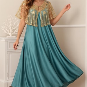 May include: A teal-colored formal gown with a flowing skirt and a gold sequined capelet. The capelet has a sheer, delicate appearance. The dress is floor-length and paired with neutral-toned heels. The overall style is elegant and suitable for special occasions.