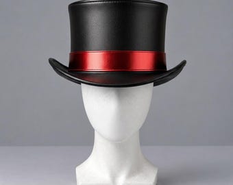 May include: A black top hat featuring a smooth, matte finish and a wide, structured brim. The base of the crown is encircled by a vibrant, metallic red ribbon band that provides a distinct contrast against the dark material of the hat.
