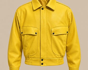 May include: A bright yellow jacket featuring a classic collar, long sleeves with cuffs, and two large front pockets with flaps. The garment includes a front placket with black snap buttons and an elasticized waistband at the bottom hem.