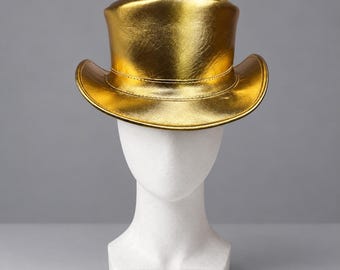 May include: A metallic gold top hat with a structured crown and a curved brim. The hat features a smooth, reflective surface with visible stitching along the base of the crown where it meets the brim, creating a distinct, polished appearance.