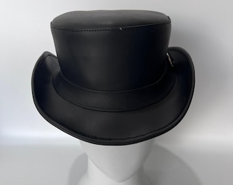 May include: A black top hat with a flat crown and a curved brim. The hat features a smooth, matte finish and a structured band encircling the base of the crown. The design is simple and uniform in color, showcasing a classic silhouette.