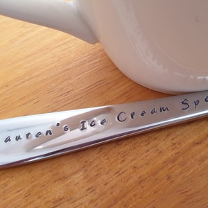 May include: A personalized stainless steel ice cream spoon with the text "Lauren's Ice Cream Spoon" engraved on it.