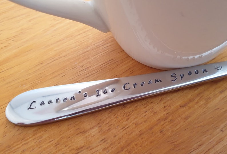 May include: A personalized stainless steel ice cream spoon with the text "Lauren's Ice Cream Spoon" engraved on it.