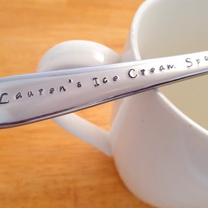 May include: A silver ice cream spoon with the words "Lauren's Ice Cream Spoon" engraved on the handle.