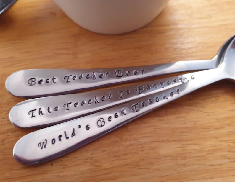 May include: Three silver spoons with engraved messages: "Best Teacher Ever", "This Teacher Is Fantastic", and "World's Best Teacher".