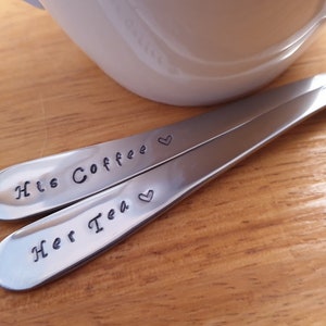 Pu&ograve; includere: Due cucchiai d'argento con cuori incisi e il testo "His Coffee" e "Her Tea".