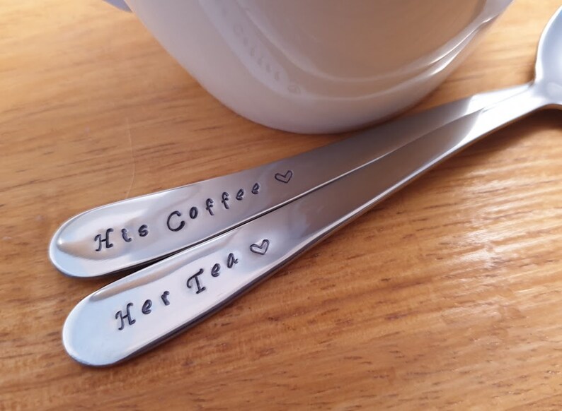Pu&ograve; includere: Due cucchiai d'argento con cuori incisi e il testo "His Coffee" e "Her Tea".