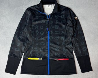 May include: Black zip-up jacket with a pattern of gray symbols. The jacket has a blue zipper, black cuffs, and a black bottom section with yellow and red accents. A small logo is on the upper right.