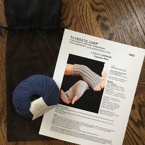 May include: A close-up of a knitting pattern for fingerless mitts using Plymouth yarn. The pattern is titled "Cuzco Cashmere Fingerless Mitts" and includes instructions for knitting with two colors of yarn. The pattern is free and available on the Plymouth Yarn website.