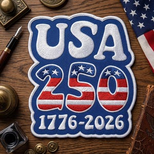 May include: A blue, white, and red embroidered patch with the text "USA 250 1776-2026". The patch features the American flag colors and stars. The patch is likely a commemorative item.