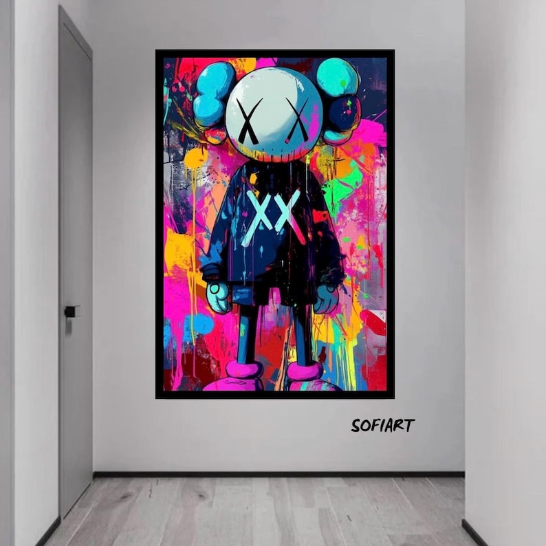 K&ouml;nnte beinhalten: Ein gerahmtes Kunstwerk mit einer Cartoonfigur mit wei&szlig;em Kopf, schwarzen X-Augen und einem schwarzen Outfit mit wei&szlig;en X'en. Der Hintergrund ist ein lebendiger Farbspritzer aus Pink, Gelb und Blau. Das Kunstwerk ist mit "SOFIART" signiert.