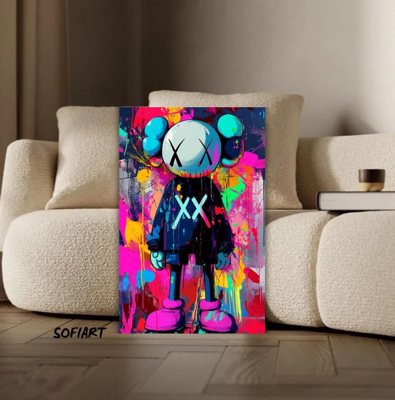 K&ouml;nnte beinhalten: Ein lebendiger Pop-Art-Druck mit einer Cartoonfigur mit wei&szlig;em Kopf, durchgestrichenen Augen und einem schwarzen Outfit mit den Buchstaben "XX". Der Hintergrund ist eine farbenfrohe Explosion aus rosa, gelber und blauer Farbe. Das Wort "SOFIART" befindet sich unten links.