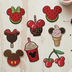 May include: A collection of colorful embroidered patches in the shape of Mickey Mouse. Designs include a watermelon slice, caramel apple, ice cream cone, cherry, and a milkshake. The patches are red, brown, green, and yellow.