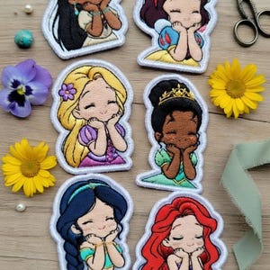 May include: A white ceramic mug with a black handle and the text "But First, Coffee" in a bold, black font. The mug is set against a blurred background, suggesting a cozy setting.