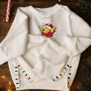 Winnie the Pooh Christmas Embroidered Sweatshirt, Embroidered Christmas Lights Cut Hem Sweatshirt, Pooh Christmas Shirt ESE580.510.2X.DT