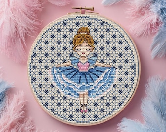 May include: A cross-stitch embroidery hoop featuring a ballerina in a blue tutu and pink bodice. The background is a geometric pattern in blue and cream. The hoop is set against a pink backdrop with pink and blue feathers.