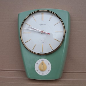 Puede incluir: Reloj de pared vintage verde menta con bisel y manecillas doradas. La esfera es blanca con marcadores dorados y el nombre de la marca "peter". Un temporizador más pequeño está debajo.