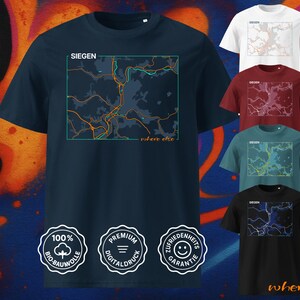 Könnte beinhalten: Marineblaues T-Shirt mit einer Karten-Grafik von Siegen, Deutschland, in einem türkisfarbenen Rahmen. Der Text "SIEGEn" befindet sich über der Karte und "where else" darunter. Weitere Shirts in Weiß, Burgunderrot, Türkis und Schwarz sind ebenfalls abgebildet.