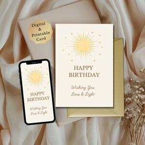 Puede incluir: Una tarjeta de cumpleaños digital e imprimible con un diseño de sol y las palabras "Happy Birthday" y "Wishing You Love & Light". La tarjeta se muestra en la pantalla de un teléfono, con un sobre y una pegatina decorativa.