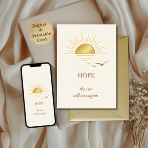 Puede incluir: Tarjeta digital e imprimible con un diseño de sol dorado, la palabra "HOPE" y la frase "the sun will rise again". Un smartphone muestra el mismo diseño. La tarjeta está sobre un fondo beige.