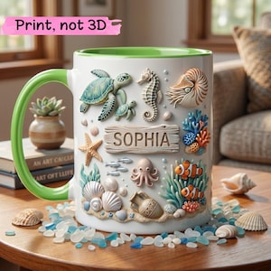 Puede incluir: Taza de cerámica blanca con asa y borde verdes, decorada con criaturas marinas en estilo 3D, incluyendo una tortuga, un caballito de mar y un pulpo. La taza presenta el nombre "SOPHIA" en un letrero de madera. El texto "Print, not 3D" está en la parte superior izquierda.