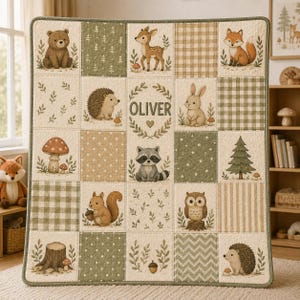 May include: A quilted baby blanket featuring a patchwork design with illustrations of a bear, deer, fox, hedgehog, rabbit, raccoon, owl, and squirrel. The quilt includes patterns of gingham, stripes, dots, and leaves in shades of green, beige, and white, with the name OLIVER printed in the center.