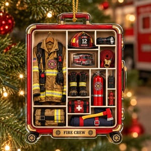 Könnte beinhalten: Ein rechteckiges, rot gerahmtes Ornament in Kofferform mit einer Miniatur-Feuerwehrausrüstung. Es enthält eine beigefarbene Jacke, einen Helm mit der Aufschrift 12, ein Bild eines Feuerwehrautos, Stiefel, einen Feuerlöscher, einen Schlauch und eine Axt.