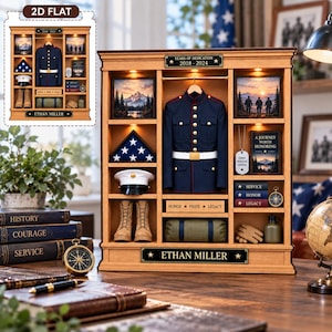 Puede incluir: Una vitrina de madera con un uniforme militar en miniatura, una bandera plegada, una gorra de servicio blanca, botas, una bolsa de lona y arte paisajístico enmarcado. Incluye placas con "YEARS OF DEDICATION 2018-2024", "HONOR PRIDE LEGACY" y "ETHAN MILLER".