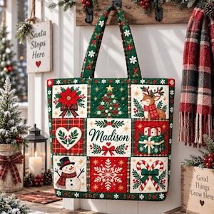 Puede incluir: Un bolso de tela acolchado con una cuadrícula de motivos navideños que incluye una flor de pascua, un árbol decorado, un reno, un corazón con acebo, el nombre Madison, regalos, un muñeco de nieve, un copo de nieve y bastones de caramelo.