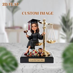 Può includere: Statuetta di una giudice in toga nera e tocco, con un martelletto. La statuetta è seduta accanto a una bilancia dorata. La base recita "In Law We Trust • Amy".