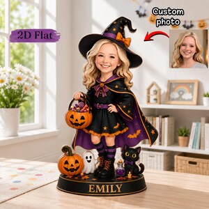 May include: A custom figurine of a child dressed as a witch, wearing a black hat and cape with orange stars and bats. The figure holds a jack-o'-lantern candy bucket, stands next to a black cat and a ghost, and features the name EMILY on the base.
