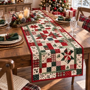 May include: A rectangular quilted table runner featuring a patchwork design with red, green, and cream colours. The pattern includes star motifs, small pine trees, and holly leaf prints, finished with a solid red border along the outer edges.
