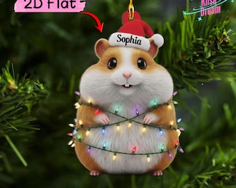 May include: A 2D flat Christmas ornament featuring a brown and white hamster wearing a red Santa hat with the name Sophia printed on the white brim. The hamster is wrapped in a string of colorful glowing Christmas lights hanging by a gold cord.