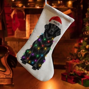 May include: A Christmas stocking with a black dog wearing a Santa hat and string lights. The dog's name, "Nick", is printed on the hat. The stocking is off-white and has a festive holiday theme.