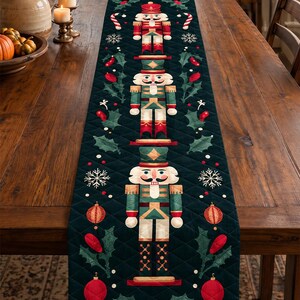 Peut inclure: Un chemin de table matelassé vert foncé orné d'un motif vertical répétitif composé de trois casse-noisettes, de baies de houx rouges, de feuilles vertes, de flocons de neige blancs, de sucres d'orge et de boules de Noël rouges.