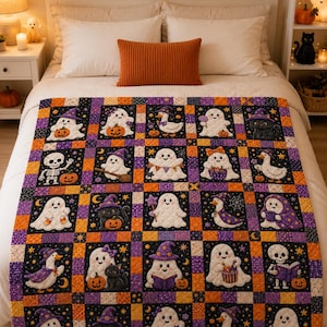 May include: A rectangular quilt featuring a grid of squares with Halloween-themed illustrations including ghosts, black cats, ducks, and skeletons wearing hats, holding pumpkins, or reading books, separated by orange, purple, and black patterned borders.
