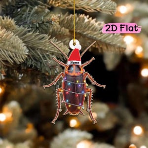 May include: A 2D flat cockroach ornament featuring a brown insect wrapped in colorful Christmas lights and wearing a red and white Santa hat with the text Name printed on the brim, suspended by a thin gold string for holiday decoration.