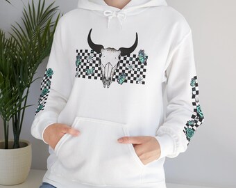 Può includere: Felpa con cappuccio bianca con grafica di teschio di toro, farfalle e fiori su sfondo a scacchi bianco e nero. Le maniche presentano un motivo a scacchi con rose e farfalle turchesi. Con tasca frontale e cappuccio con coulisse.
