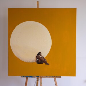 May include: An original painting on canvas depicting a seated figure against a large, textured, off-white circle. The background is a solid mustard yellow. The figure wears a white top and is seated with legs extended.