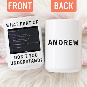 May include: Two white ceramic mugs with pink handles. The left mug features a black graphic of computer code inside a screen with the text "WHAT PART OF" above and "DON'T YOU UNDERSTAND?" below. The right mug displays the name "ANDREW" in black.