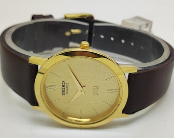Reloj de pulsera japonés vintage Seiko de cuarzo delgado para hombre, redondo, chapado en oro, reacondicionado, con esfera dorada.
