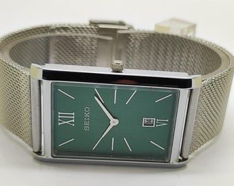 Reloj de cuarzo Seiko vintage con esfera verde y correa de malla rectangular.