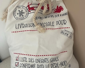 May include: A white canvas Santa sack with a rope drawstring. The sack is printed with red and black text and illustrations, including a reindeer and the words "Special Delivery". The text includes "List of Good Children" and "Confirmed by Father Christmas".