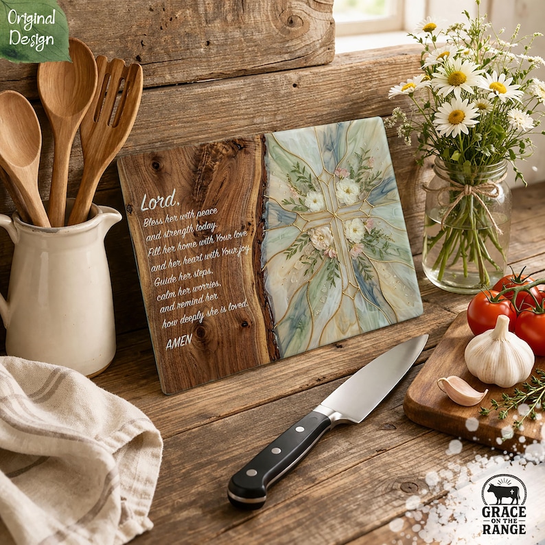 May include: A rectangular glass cutting board featuring a natural wood grain edge on the left and a floral cross design on the right. The text reads: Lord, Bless her with peace and strength today. Fill her home with Your love and her heart with Your joy. Guide her steps, calm her worries, and remind her how deeply she is loved. AMEN.
