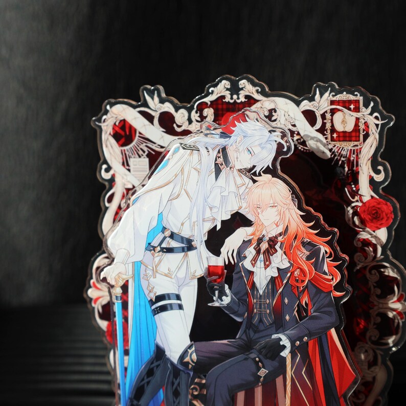 May include: Acrylic stand featuring two anime-style characters in ornate outfits. One character has white hair and a white and blue outfit, while the other has long orange hair and a black and red ensemble. The background is a decorative red and white design.