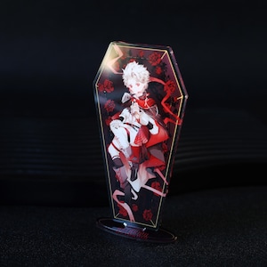 Könnte beinhalten: Ein dekorativer Acrylständer mit einer Charakterillustration. Das Kunstwerk zeigt eine Figur in roter und weißer Kleidung, vor einem Hintergrund aus roten Rosen in einem Sargrahmen. Der Ständer hat einen transparenten Sockel.